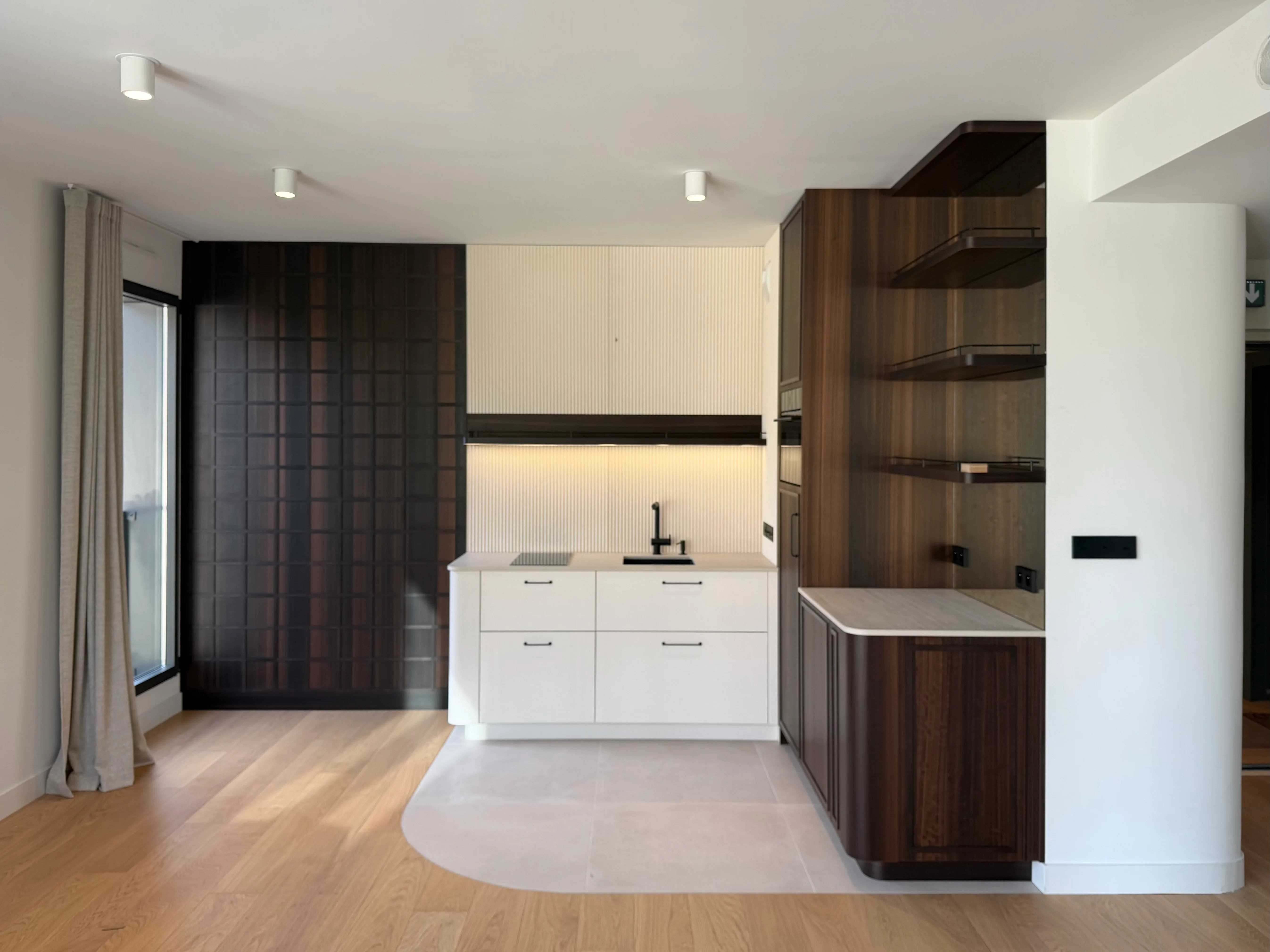 Cuisine sur-mesure avec îlot et plan de travail bois, dans une pièce lumineuse