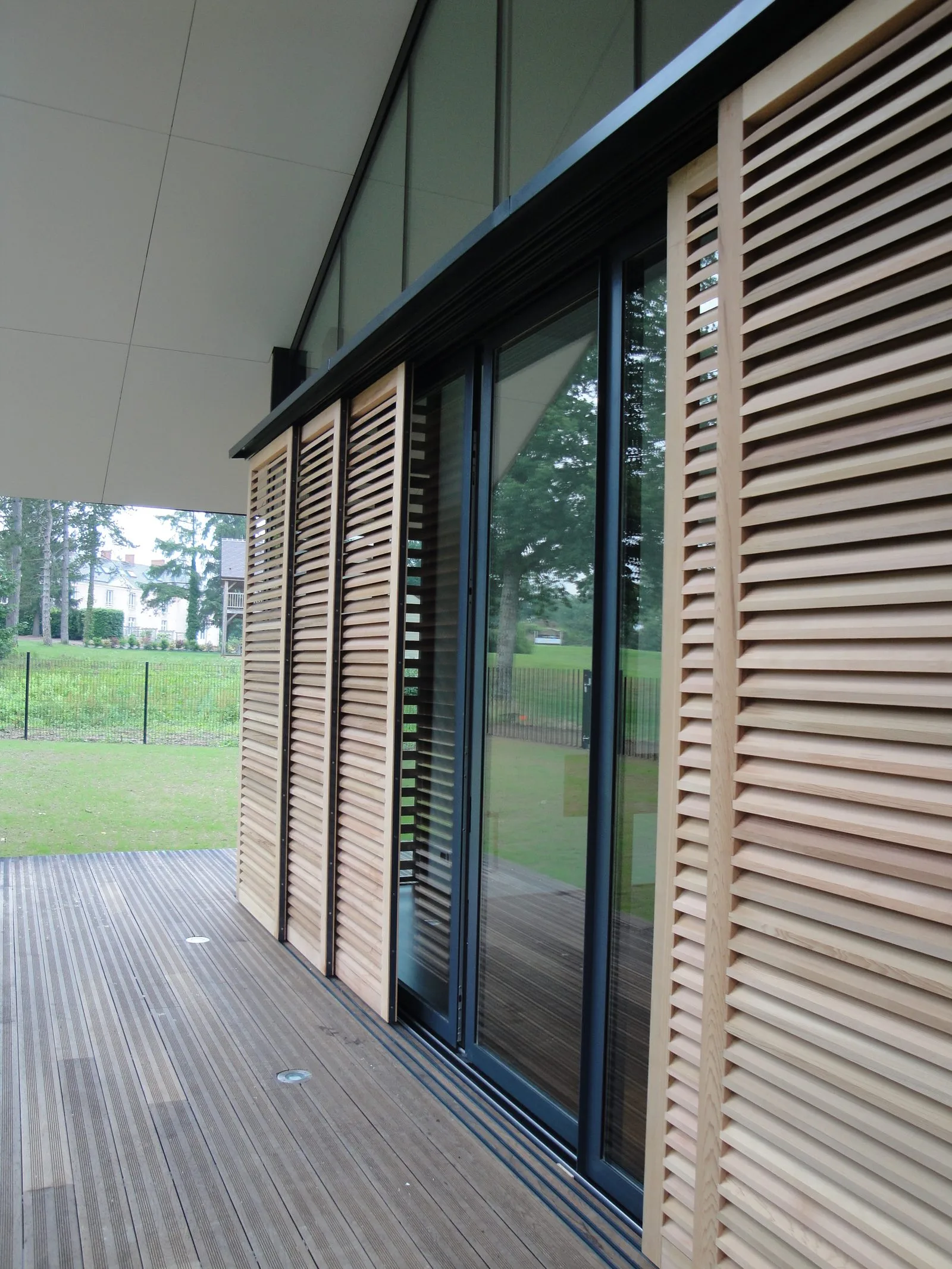 Volets persiennés bois coulissants, menuiserie extérieure fabriquée et posée par Arcobois